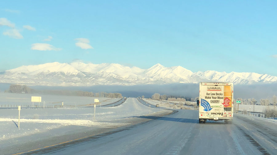 雪山を望む凍った高速道路を走るU-Haulのトラック